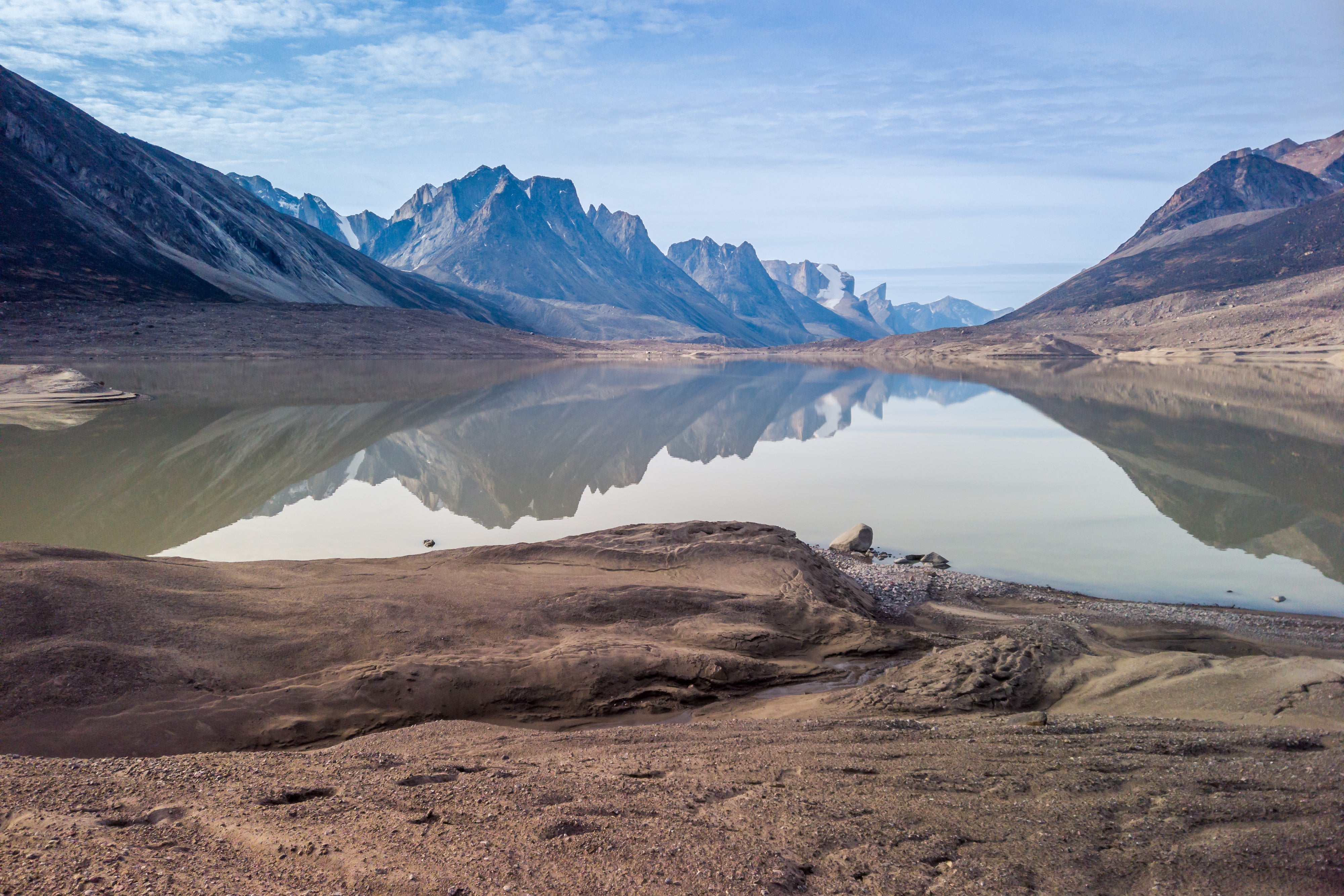 Lake surrounded by large mountains somewhere in Nunavut.