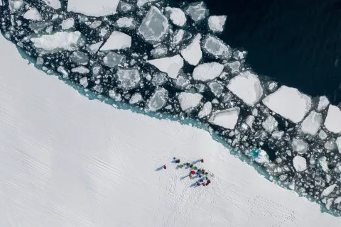 Top down shot of a small group of people at the floe edge. 
