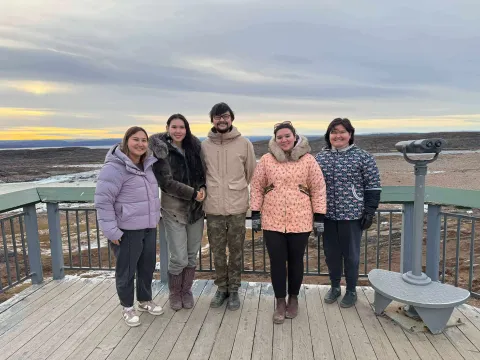 Group of Youth from the Nunavut Climate Change Youth Advisory Committee pose in front of the Silvia Grinnell Falls lookout point.